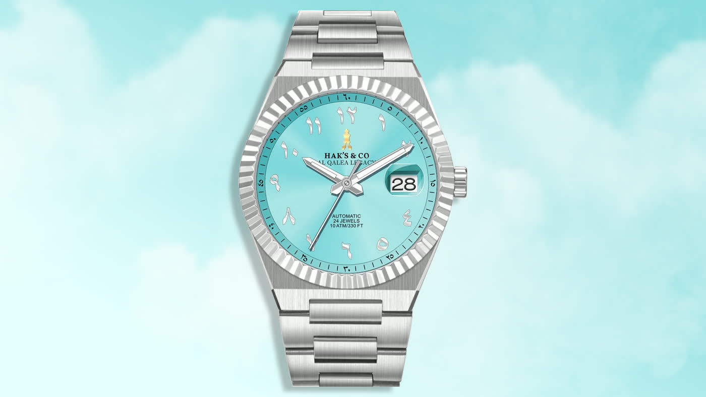 The Al-Qalea Legacy: a turquoise Arabic-numeral dial on a steel bracelet, against a bright sky